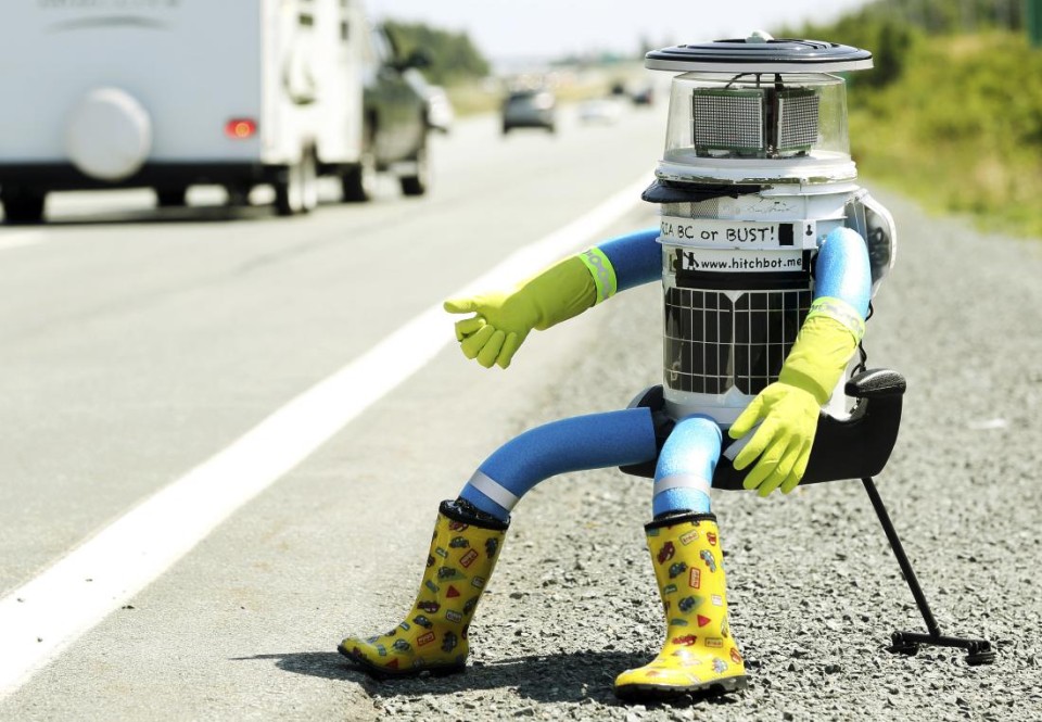 The anthropomorphic robot named hitchBOT sits on the shoulder of Highway 102 to begin its 6000 kilometer cross country journey outside of Halifax, Nova Scotia, July 27, 2014. The hitch hiking robot is part of a social experiment to see if drivers will pick up and drop off the robot in one piece to an art gallery in Victoria, British Columbia.  REUTERS/Paul Darrow (CANADA - Tags: SOCIETY SCIENCE TECHNOLOGY TPX IMAGES OF THE DAY) - RTR40APN