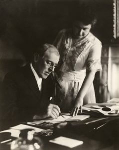 Edith Wilson assists stroke-impaired Woodrow Wilson to sign legislation.